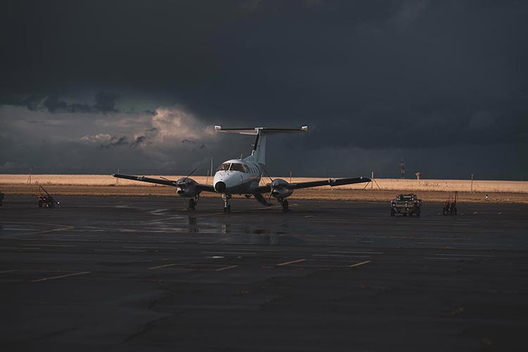 Bimoteur à hélices sur tarmac mouillé sous un ciel d'orage — PUShAUNE photographe Marseille